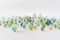 Many colorful transparent marbles on white background 