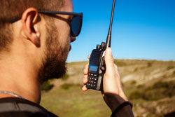 Young handsome man talking on walkie talkie radio