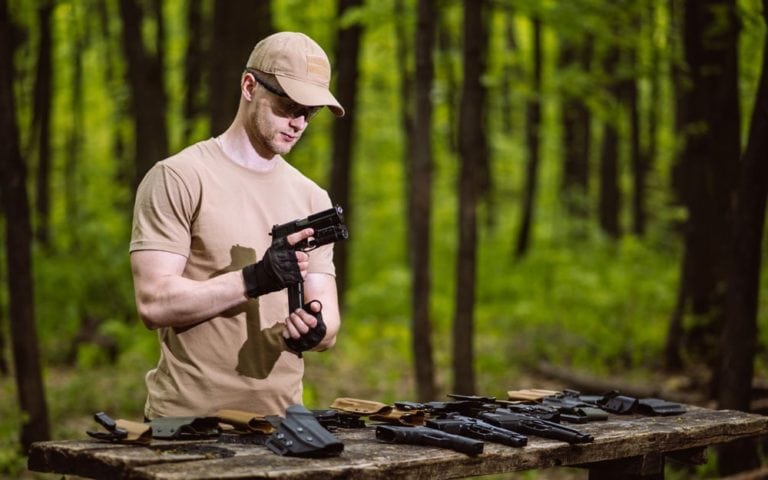 Guy in the woods tests his weapons for shooting sports