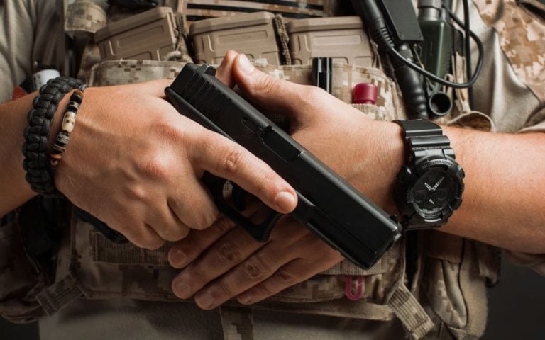 Close-up of a man pulls a gun from his holster