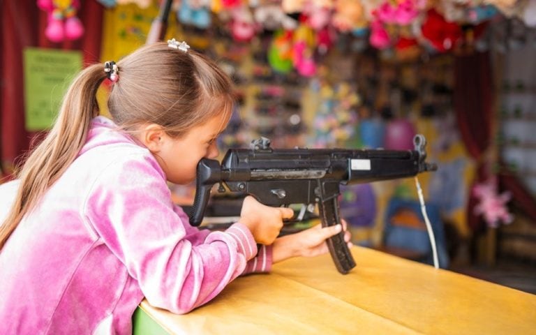 Girl shoots from children's toy gun in children's entertainment center