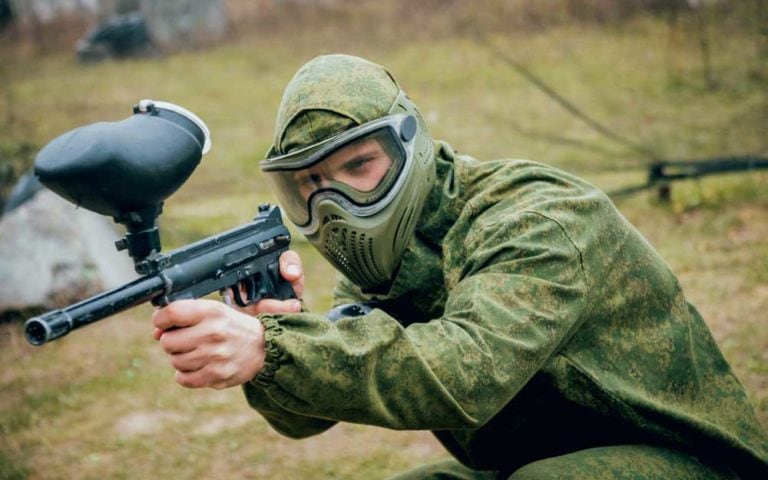 Man with gun playing at paintball. outdoors