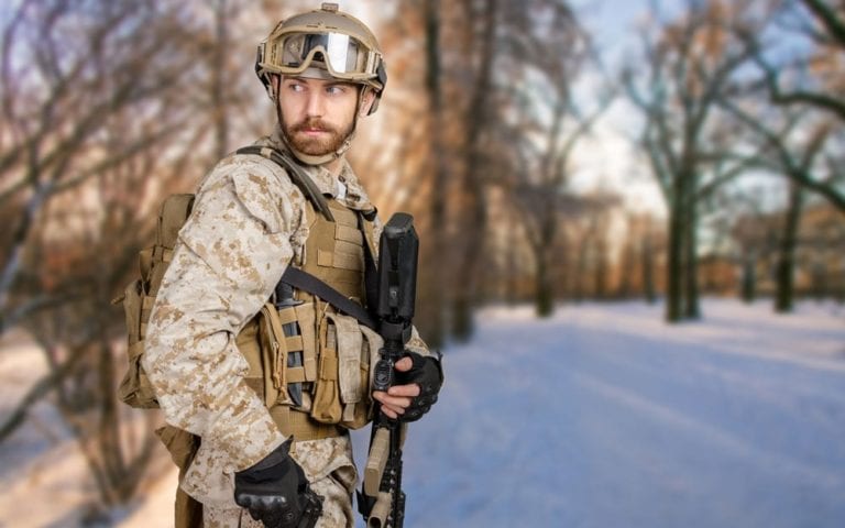 Modern soldier with rifle in a forest